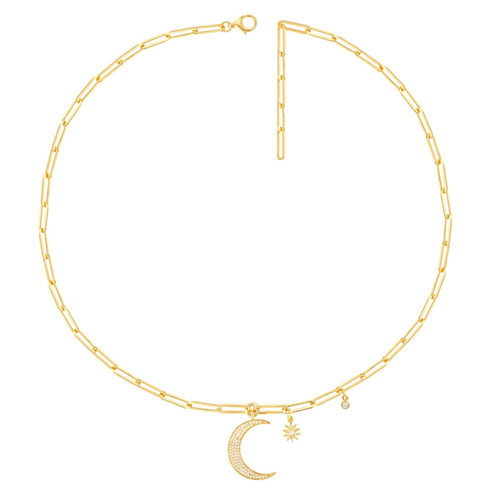 A yellow-gold necklace is laid out against a white background. The necklace features a diamond-set moon motif, a sun motif, and a round-shaped dangle diamond on a link chain.