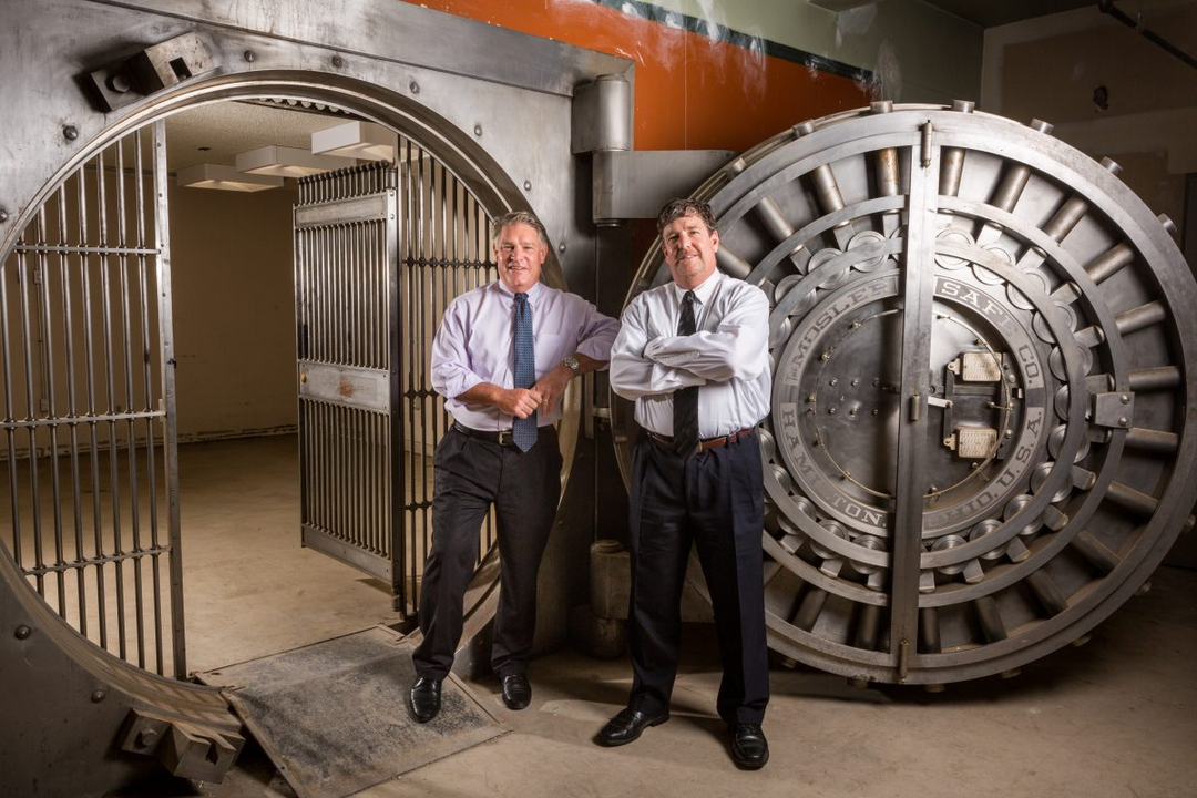 Two men wearing button-downs and ties posing outside the Richter and Phillips vault.