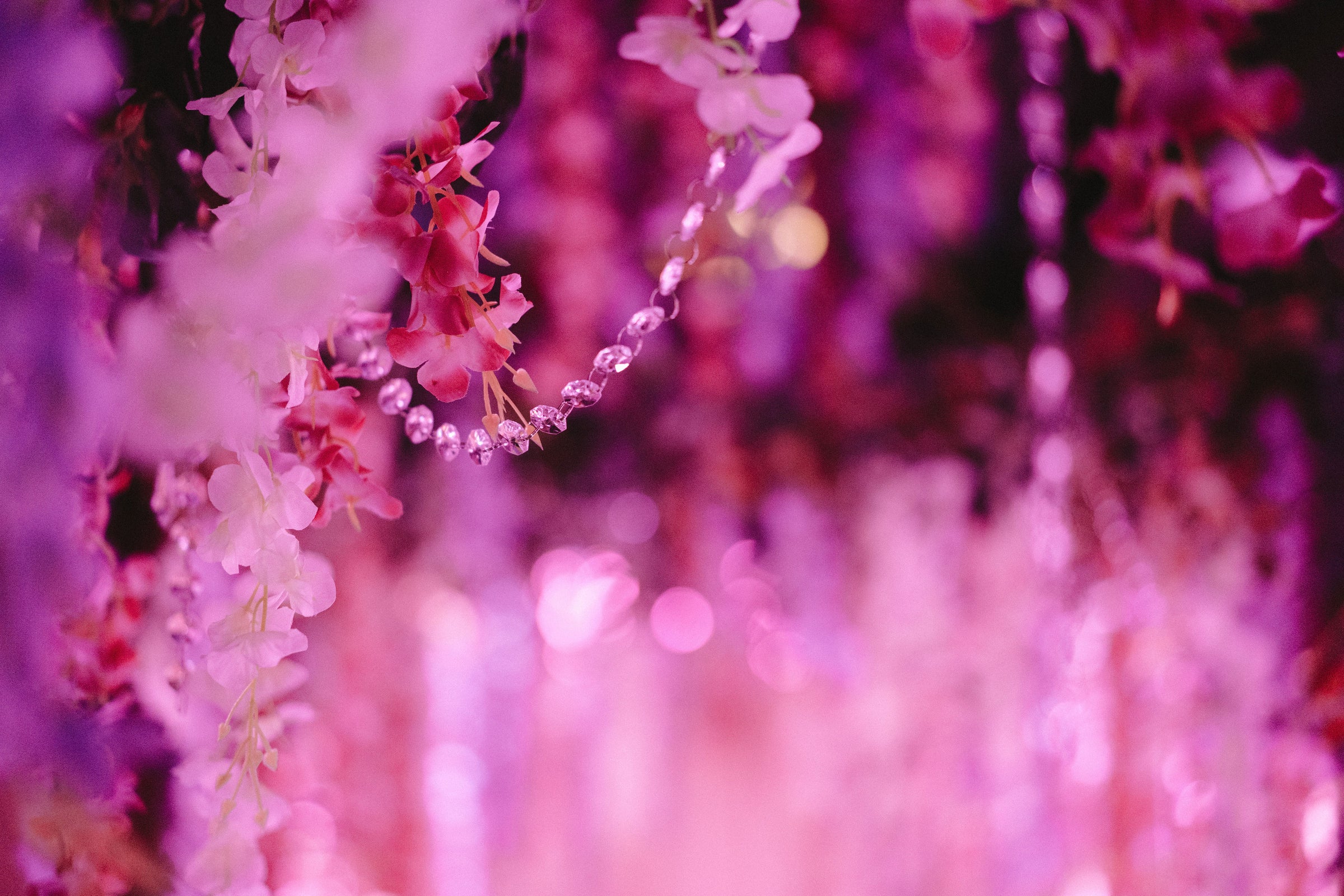 A close-up of the Ladies Night 2022 backdrop showcasing the draped diamonds and pink and white flowers.