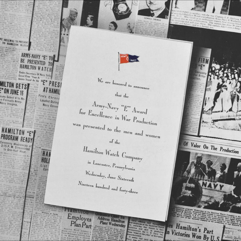 An Army-Navy "E" Award for Excellence in War Product invitation and newspapers in the background.