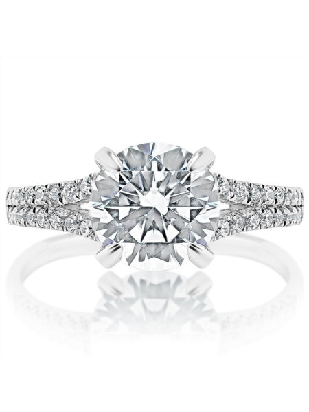 A white gold ring is set against a white background. It features a prong-set round-shaped diamond center stone and two rows of diamond-set connecting bands.