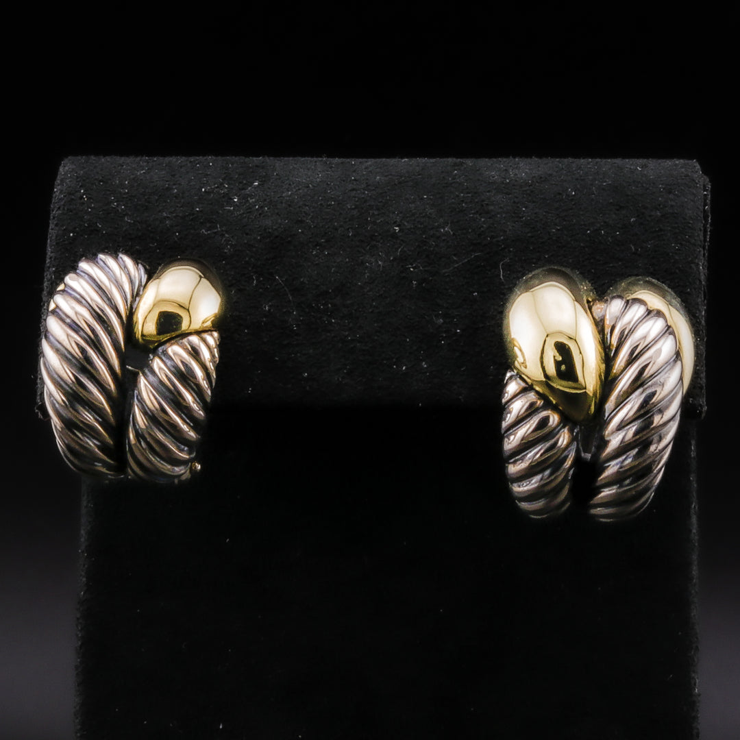 A pair of mixed metal earrings displayed against a black background. The earrings feature a yellow gold loop and white gold stripe detailing.