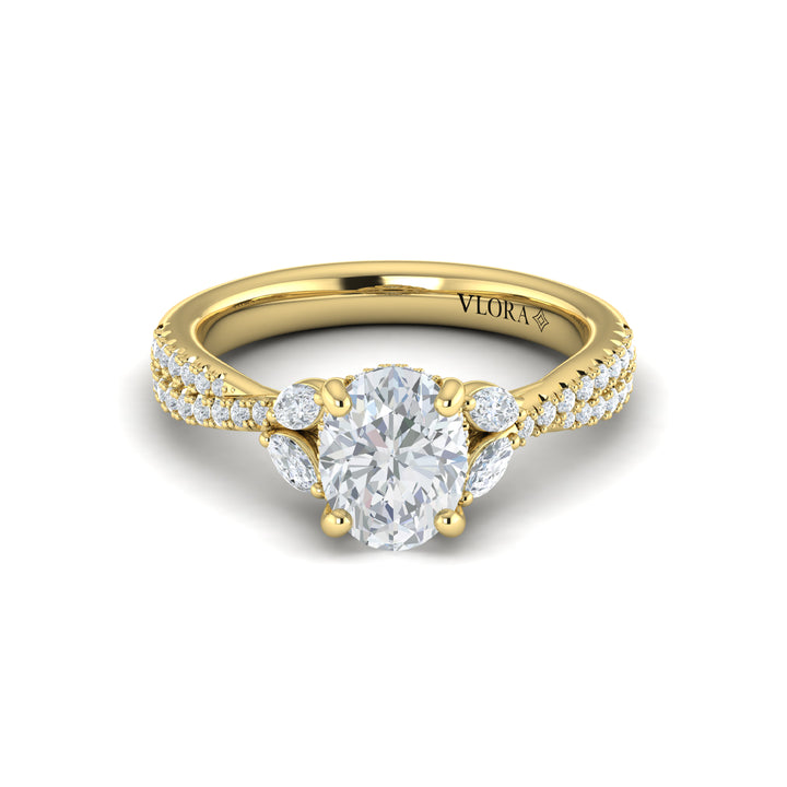 A front view of a yellow gold engagement ring is set against a white background. The engagement ring features a vine-inspired band of intertwining pavé diamonds. Two marquise diamonds rest like leaves, embracing the oval center diamond in a Vlora signature V-shaped setting with a hidden halo and pave details.