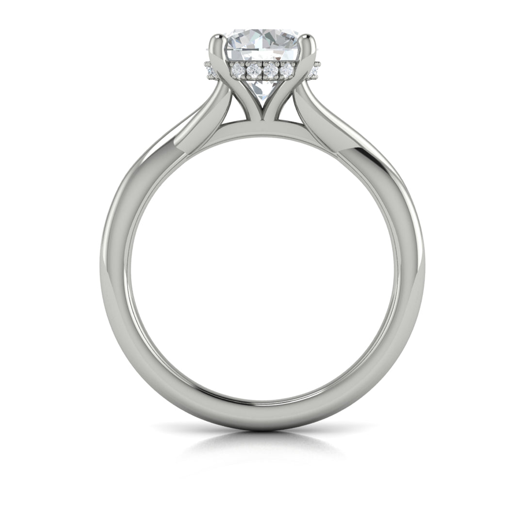 A top view of a white gold engagement ring is set against a white background. The engagement ring features a round center diamond, a cathedral setting, a hidden halo, and a twisted band design.