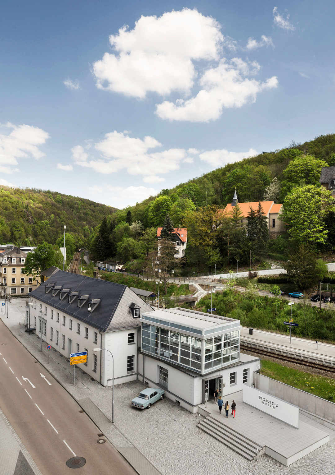 A vertical shot of a town showcasing the Nomos Glashutte building.