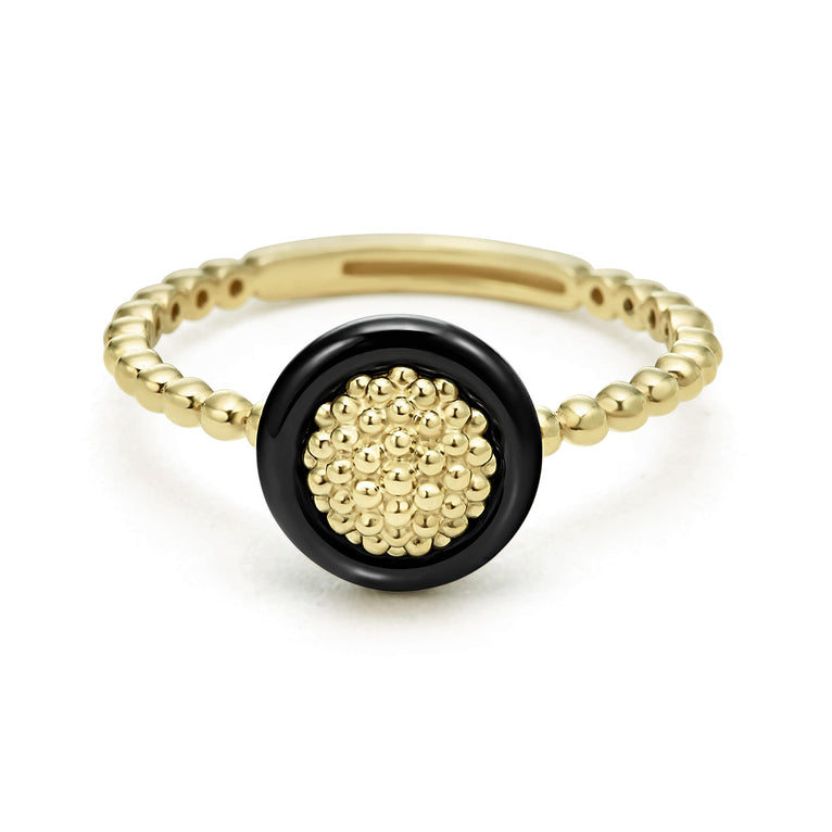 An 18K Gold ring in the middle of a white background featuring caviar beading framed by black ceramic