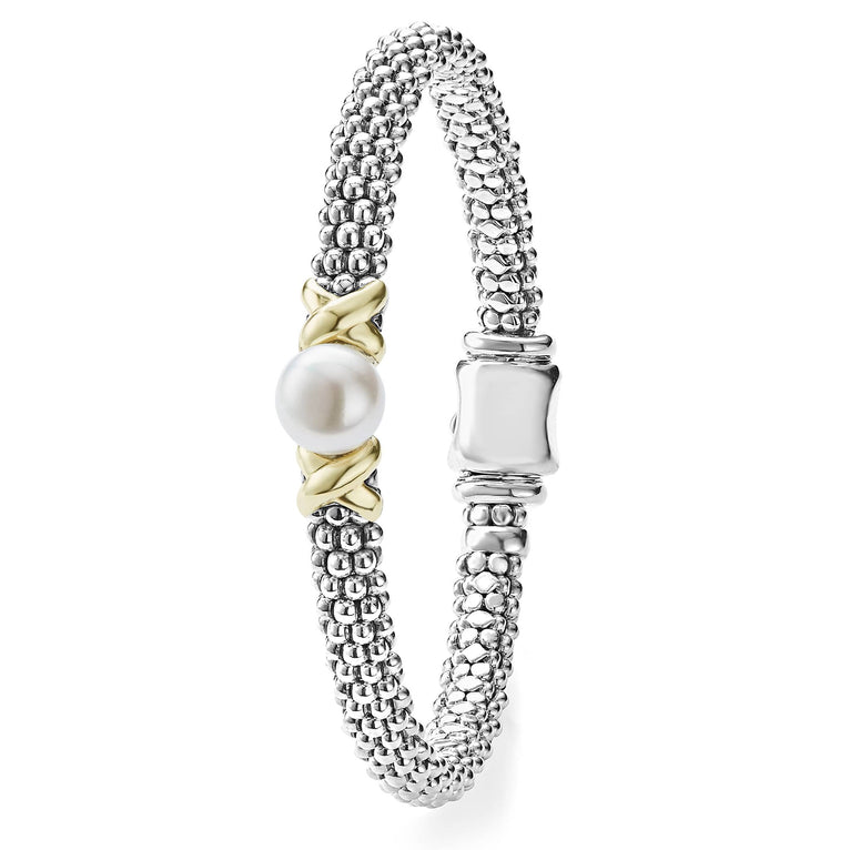 A sterling silver bracelet standing vertically in the middle of a white background featuring a freshwater cultured pearl framed by two 18K gold x stations