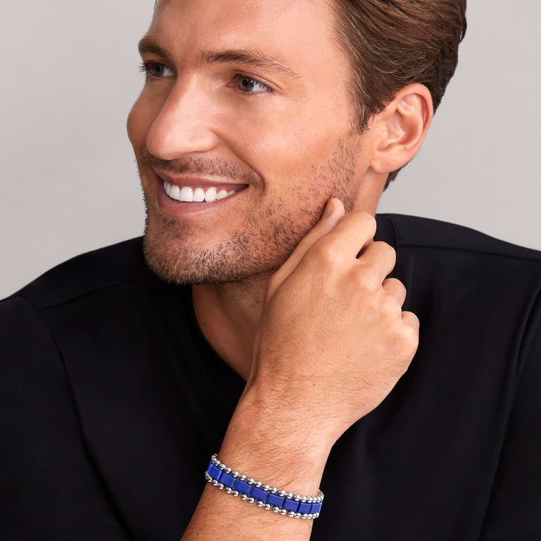 A man is wearing a stainless steel bracelet featuring matte ultramarine ceramic and caviar beading.