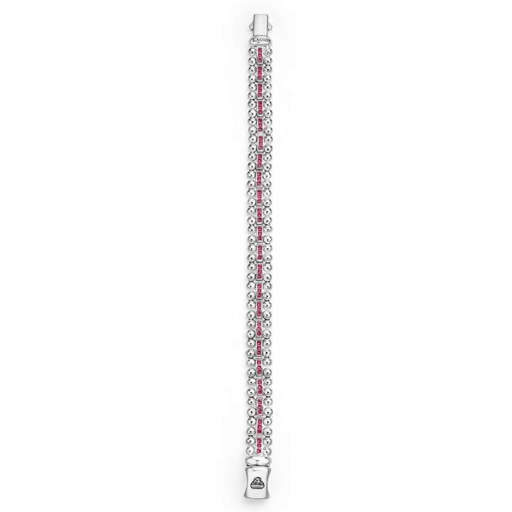 A Sterling silver link bracelet is laid vertically on a white background and features ruby gemstones and caviar bead links.