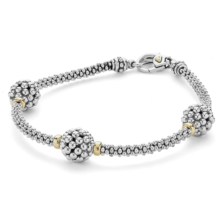 A bracelet in the middle of a white background featuring three caviar spheres accent a sterling silver beaded strand