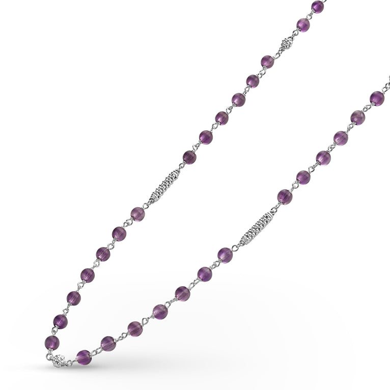 A sterling silver and ceramic beaded necklace angled to the right in the middle of a white background featuring Amethyst ceramic and silver Caviar beading.