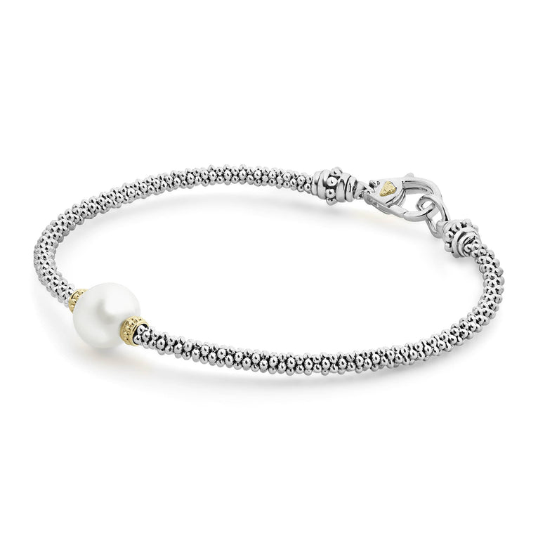 A close-up of sterling silver & 18k gold bracelet angled displayed in the middle of a white background featuring a cultured freshwater pearl station with Caviar beading in 18K gold and sterling silver