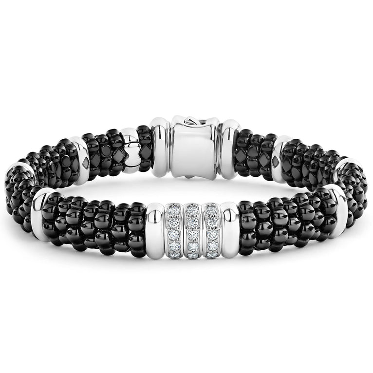 A sterling silver bracelet in the middle of a white background, featuring three diamond stations, black ceramic caviar beading, and sterling silver stations