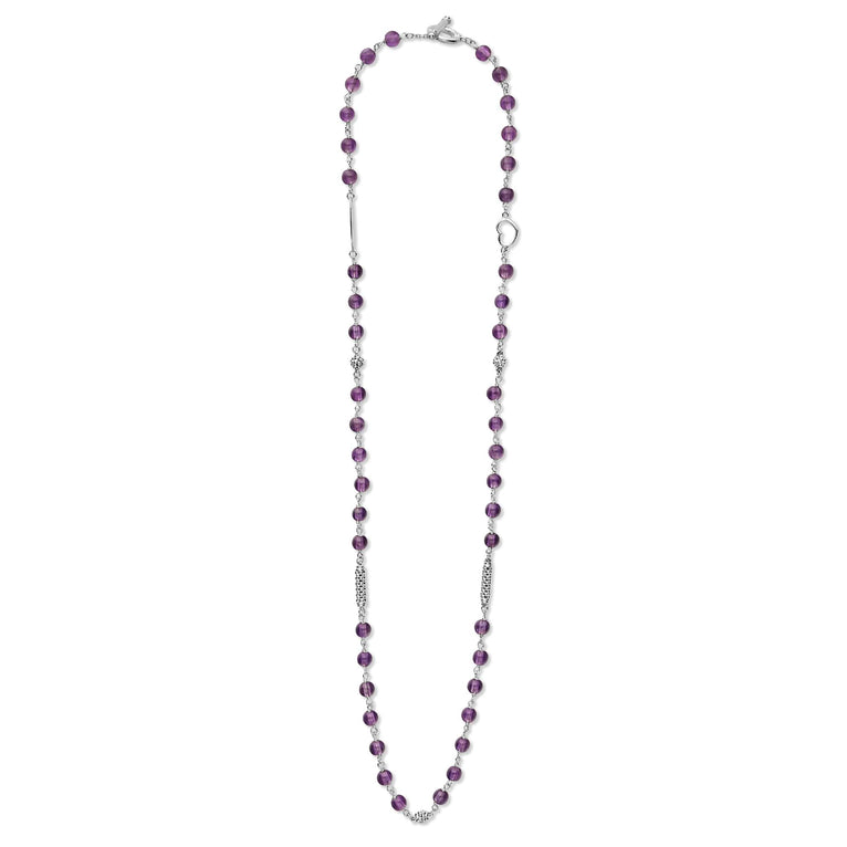 A sterling silver and ceramic beaded necklace in the middle of a white background featuring Amethyst ceramic and silver Caviar beading.