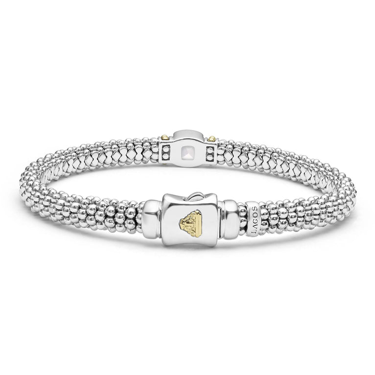 A sterling silver bracelet in the middle of a white background highlighting the clasp features a white topaz gemstone and sterling silver Caviar beading with 18K gold detailing.