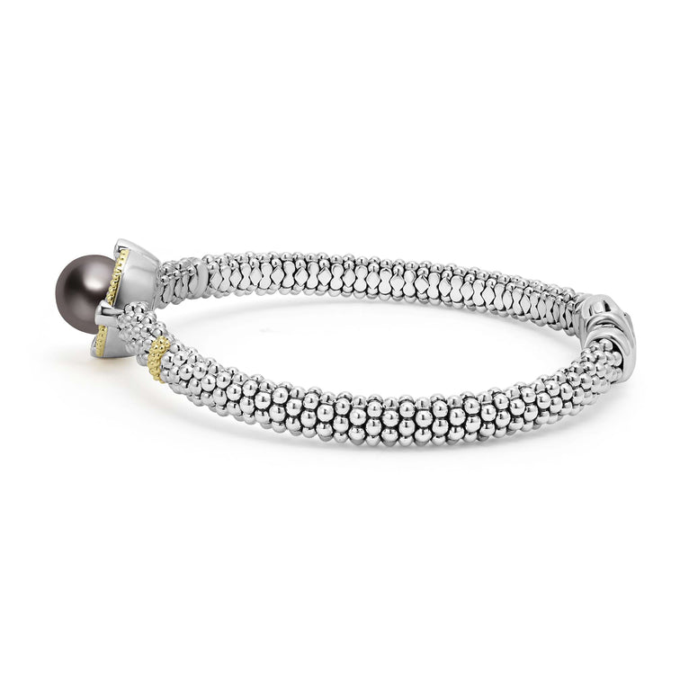 This is a side view of a Sterling silver and 18k gold bracelet on a white background. It features a Tahitian black pearl surrounded by diamonds, gold stations, and caviar beading.