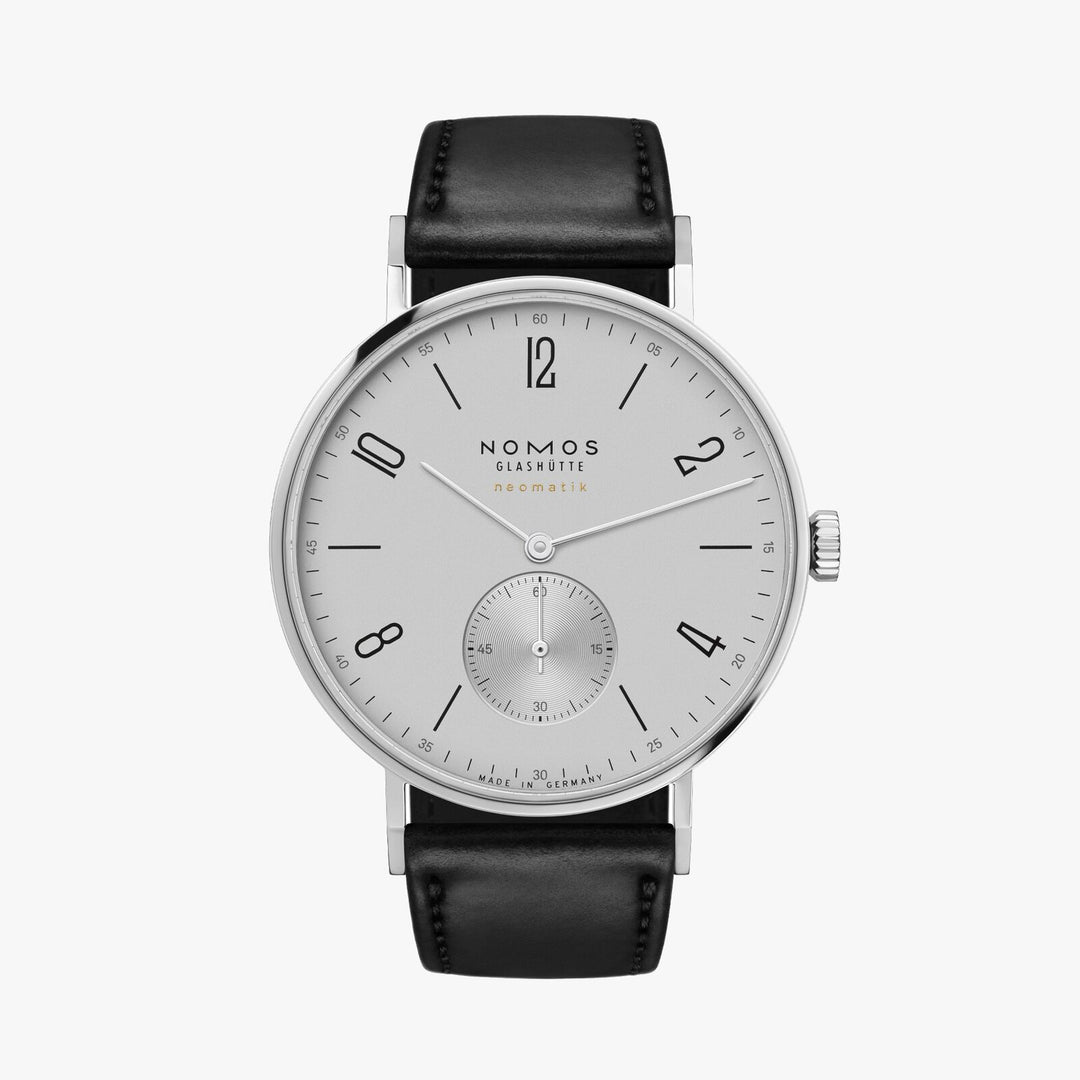 A Nomos Glashutte watch stands straight against a white background. It features a white dial, black and white hands and markers, a stainless steel bezel, and a black leather strap.