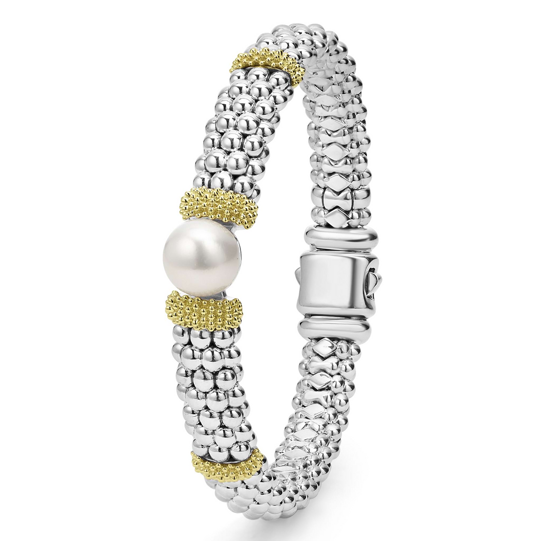 A sterling silver & 18k gold bracelet standing vertically in the middle of a white background featuring a freshwater cultured pearl, smooth sterling silver, Caviar beading, and 18K gold stations.