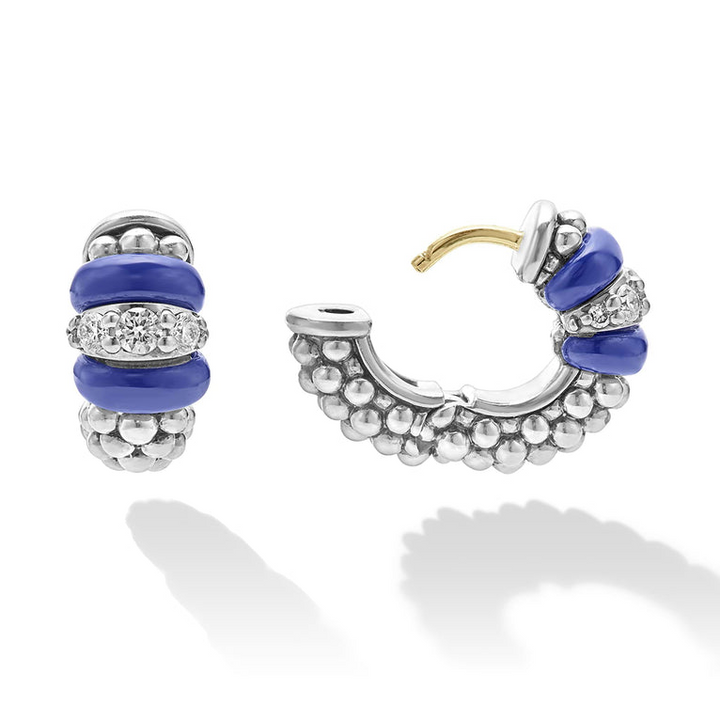 A pair of huggie earrings with smooth ultramarine ceramic and diamonds with Caviar beading. The right earring is angled to the side and unclasped.