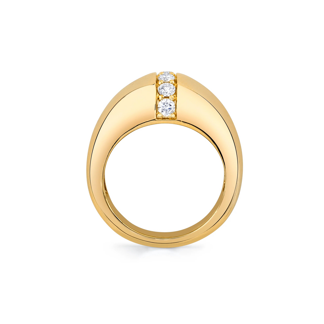 A side-view of a yellow-gold ring lies standing up against a white background. It features a unique band with a row of diamonds in the middle.