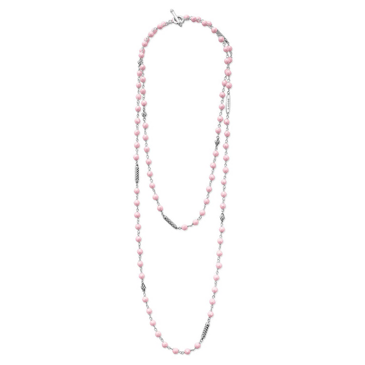 A sterling silver and ceramic beaded necklace in the middle of a white background featuring Pink ceramic and silver Caviar beading.