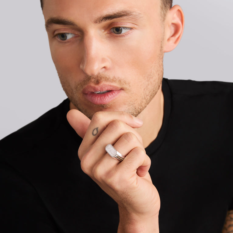 A man wearing a black top and sterling silver & 18K Gold two-tone octagon-shaped ring featuring a diamond set center and gold caviar beading.