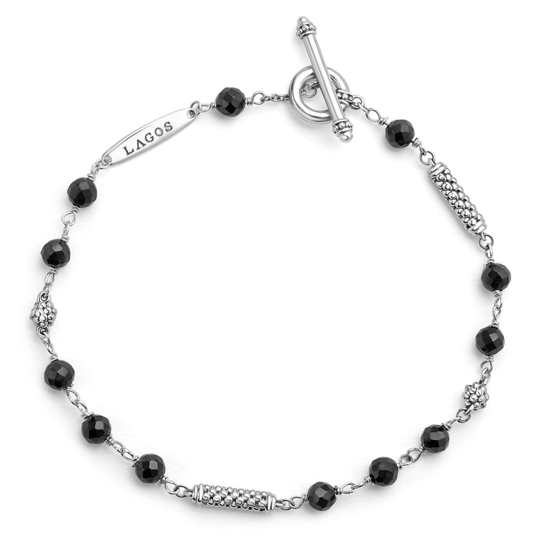 A sterling silver bracelet displayed in the middle of a white background featuring Black ceramic and sterling silver Caviar beads.