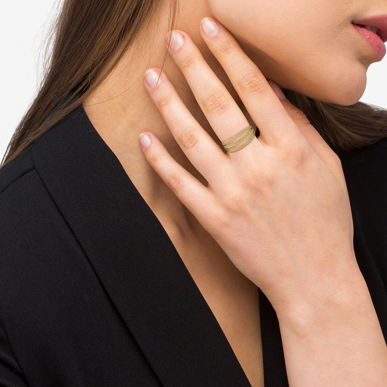 A woman wearing An 18K Gold ring in the middle of a white background featuring three rows with caviar beading.