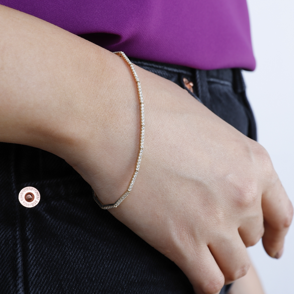 A close-up of a woman's wrist wearing a bracelet with sleek bars of pave-set diamonds.