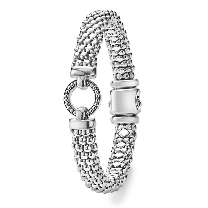 A side-view of a sterling silver beaded bracelet in the middle of a white background, featuring a detailed circle motif and caviar beading