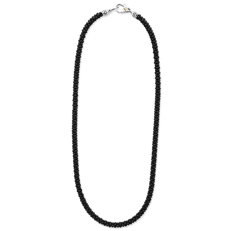 A sterling silver and ceramic beaded necklace in the middle of a white background featuring matte black ceramic caviar beading.