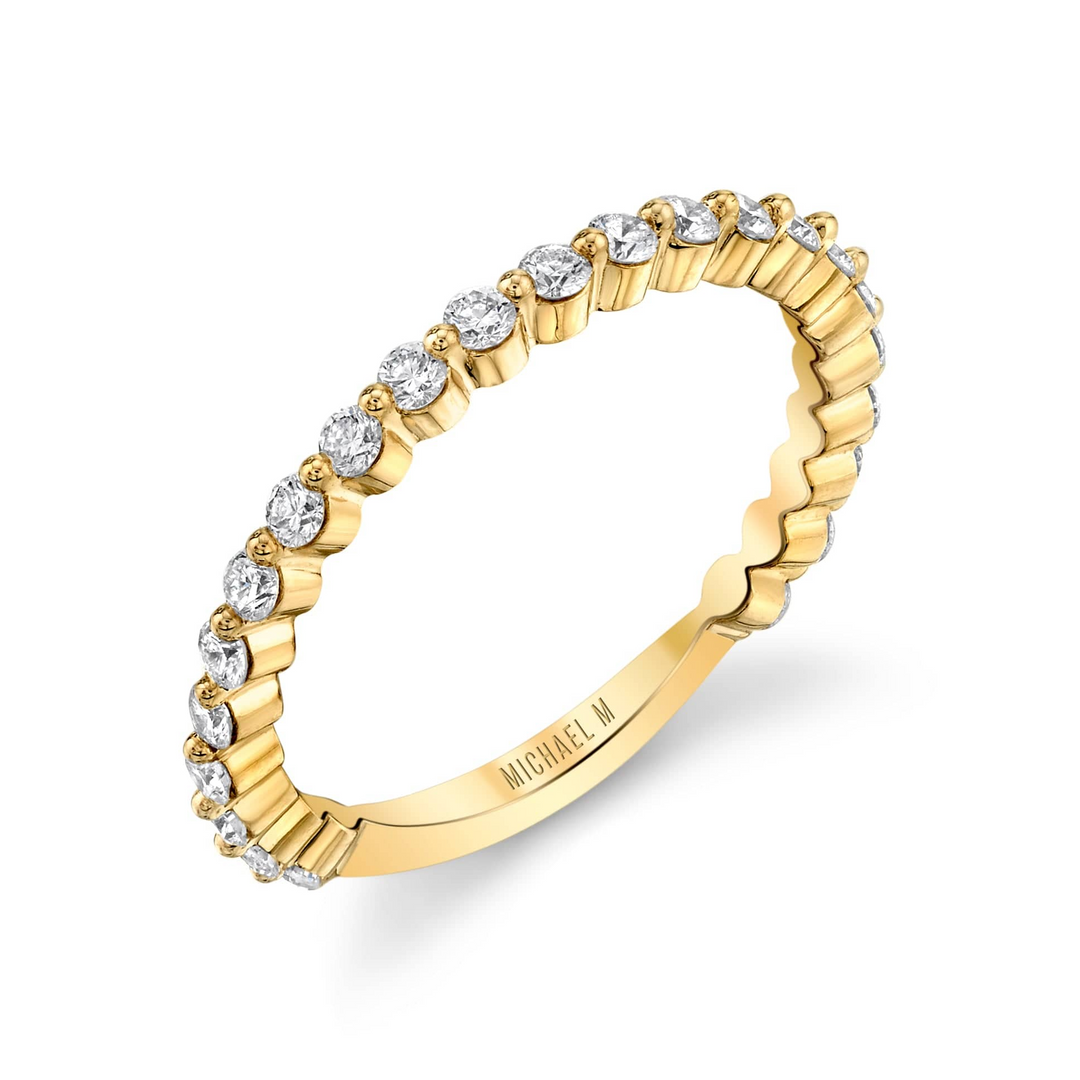 This is a close-up of the side view of the yellow-gold ring. It features a bezel set of round diamonds and a white gold band.