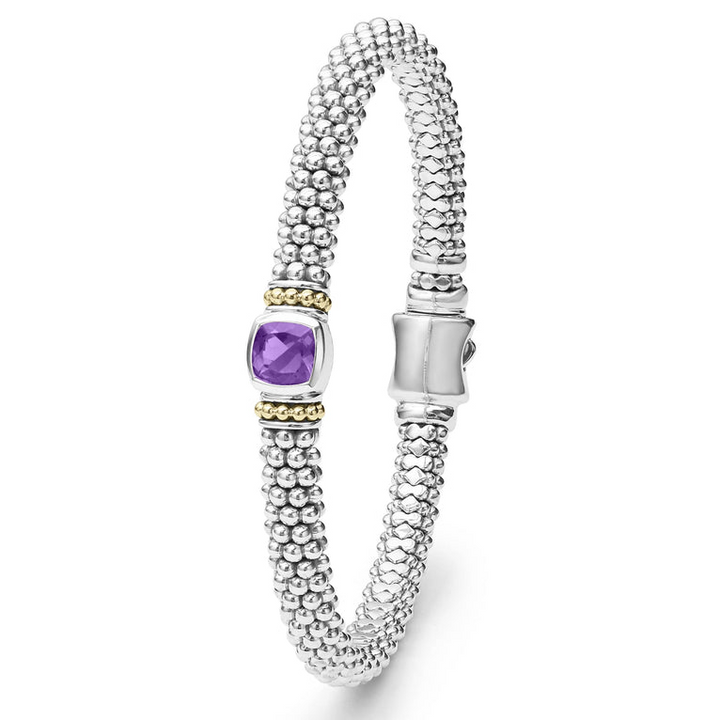 A sterling silver bracelet in the middle vertically of a white background features an amethyst gemstone and sterling silver Caviar beading with 18K gold detailing.