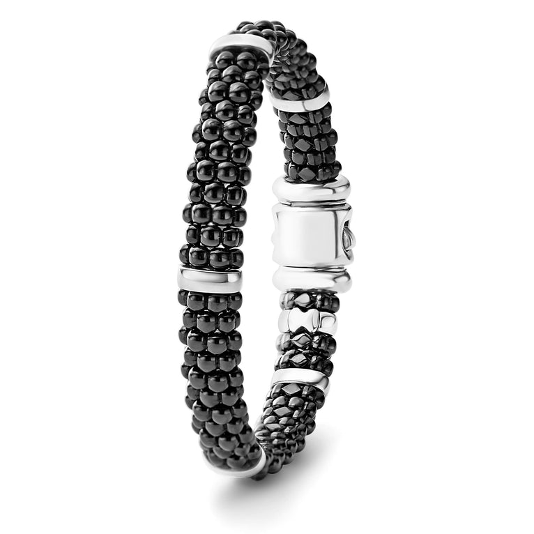 A sterling silver beaded bracelet standing vertically in the middle of a white background, featuring five sterling silver stations and black caviar beading