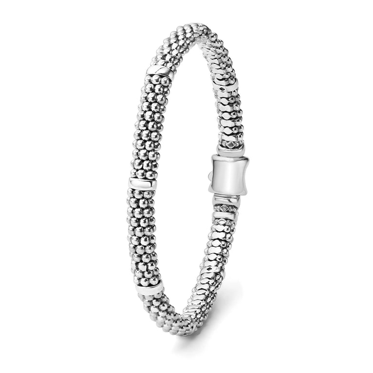 A sterling silver bracelet focusing on the clasp of a white background featuring five sterling silver stations and caviar beading.