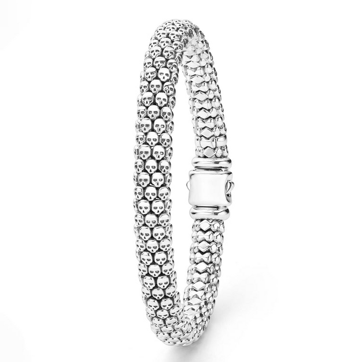 A sterling silver bracelet standing vertically in the middle of a white background featuring skull caviar beading