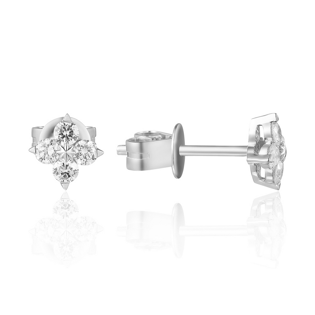 A pair of stud earrings with a flower design with round diamond clusters. The right earring is angled to the side, showing the back.