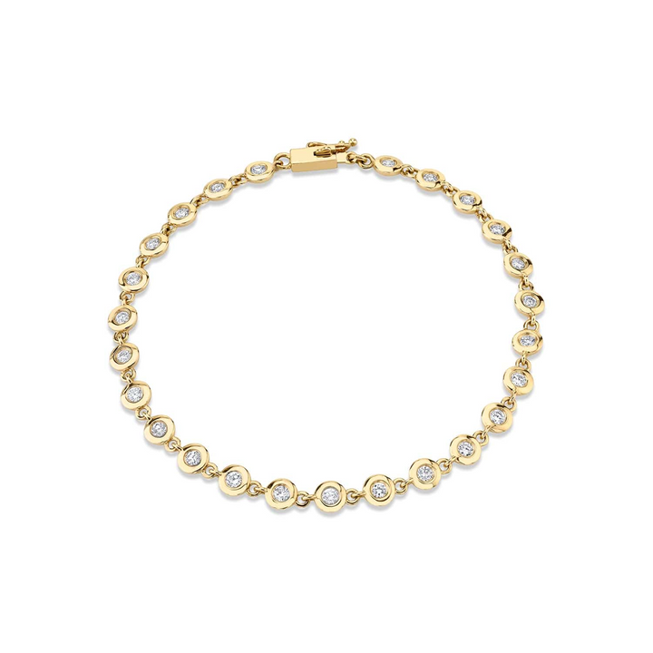 A yellow-gold bracelet lying flat against a white background. The bracelet features a row of bezel-set stones.