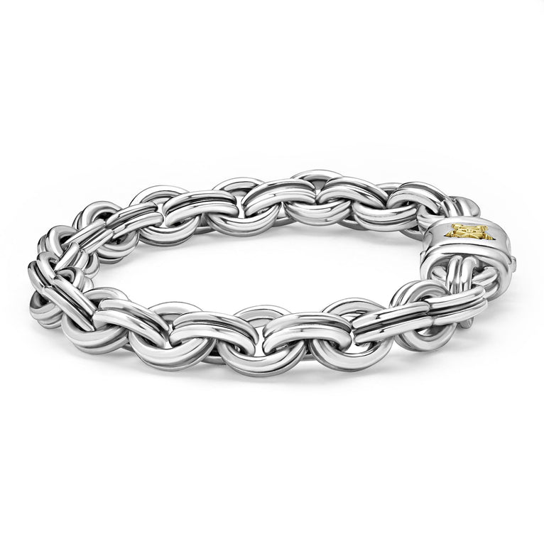 A sterling silver bracelet in the middle of a white background featuring double link chain and krunch crescent on the clasp