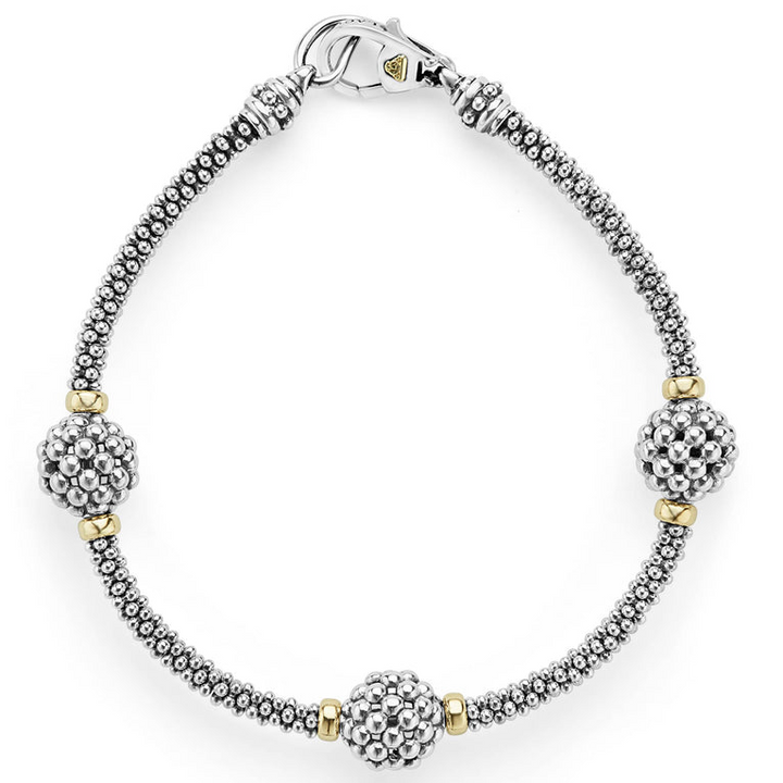 A bracelet in the middle of a white background featuring three caviar spheres accent a sterling silver beaded strand