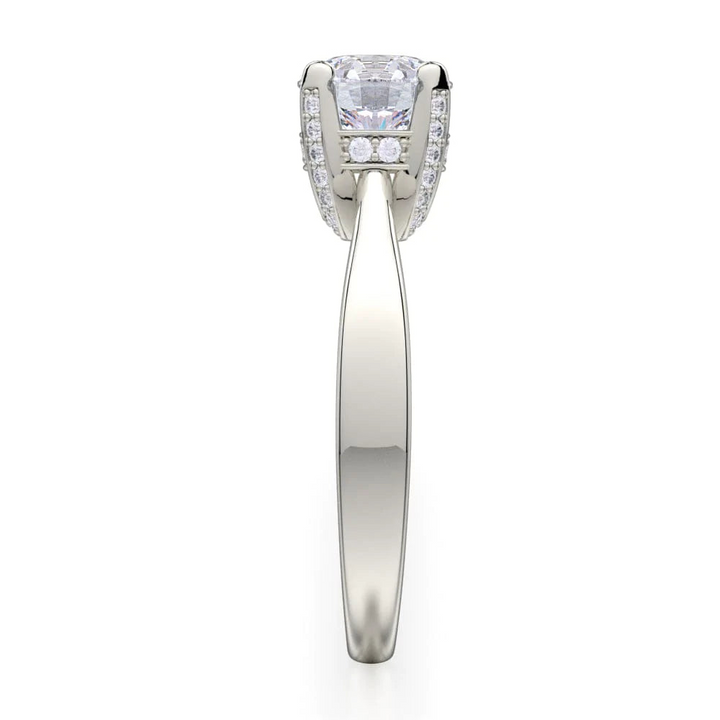 A side-view of the Pave Diamond Basket Engagement Ring, made of white gold. The side view shows the diamond's pavilion and the side of the band.