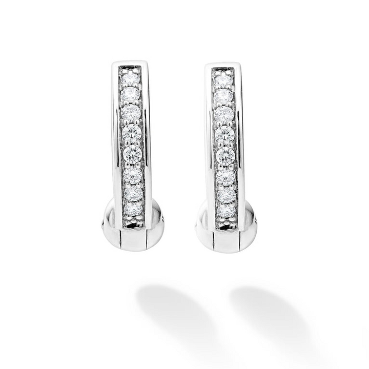 A pair of huggie earrings with diamonds set in a smooth sterling silver circle motif.