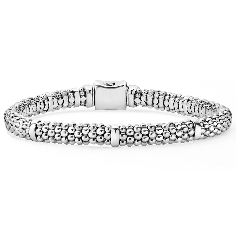 A sterling silver bracelet displayed in the middle of a white background featuring five sterling silver stations and caviar beading.