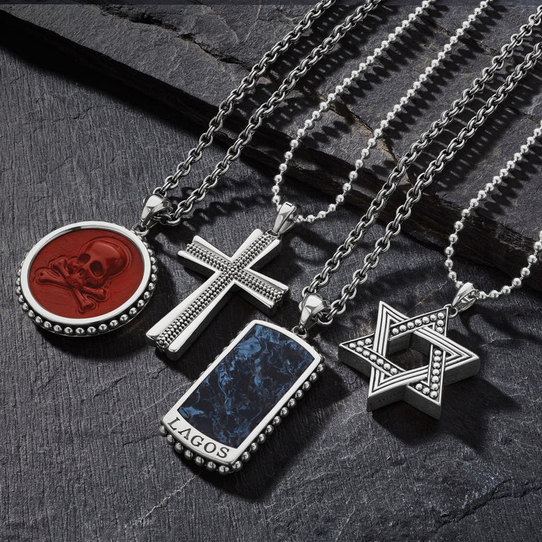 Four amulet necklaces scattered next to each other on a gray background