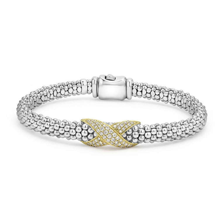 A Sterling Silver & 18k gold bracelet resting in the middle of a white background. The bracelet features a diamond-set X station, caviar beading, and a stainless steel clasp.