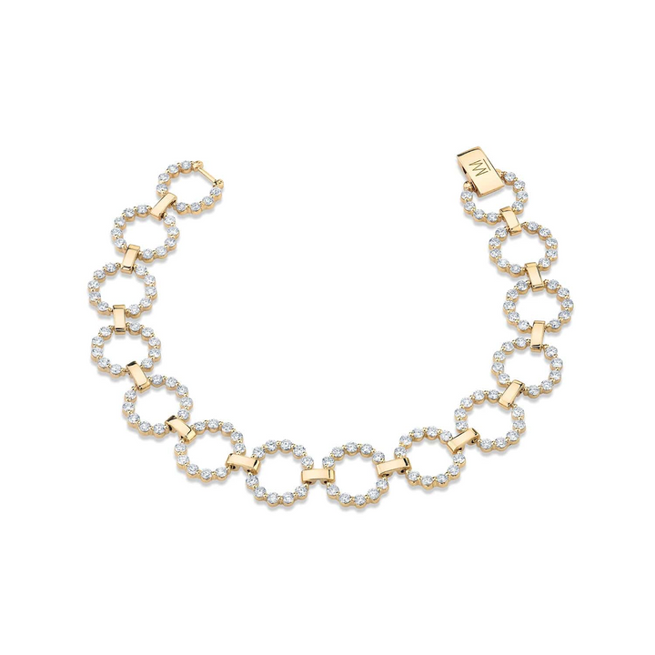 A yellow-gold bracelet lying flat against a white background. The bracelet features a row of bezel-set round stones with circle links.