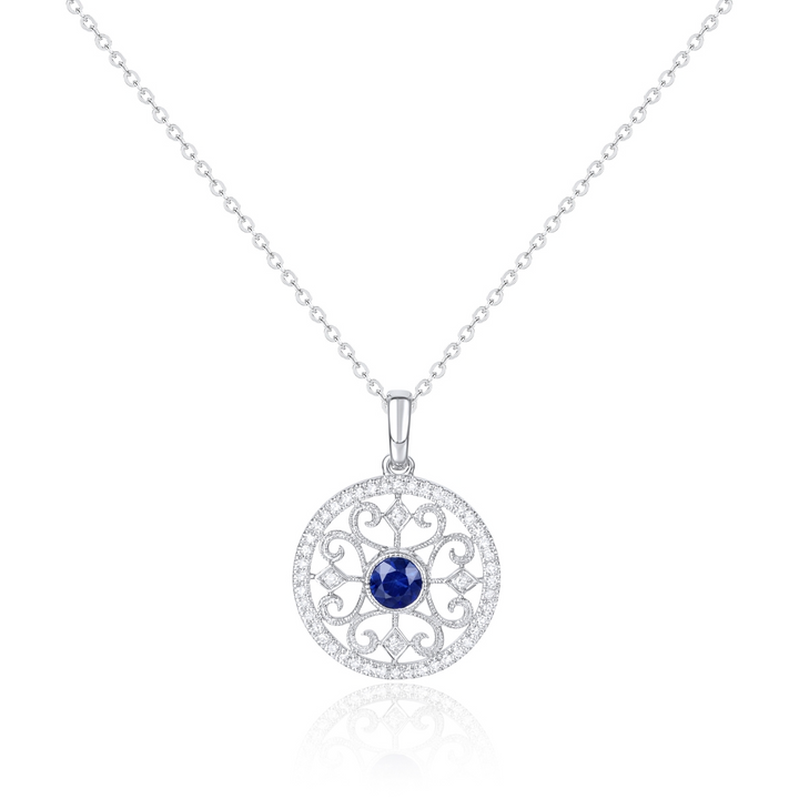 A close-up of a white-gold Filigree Necklace against a white background. The necklace features a sapphire round diamond in the center with a twist design on the diamond-set pendant.