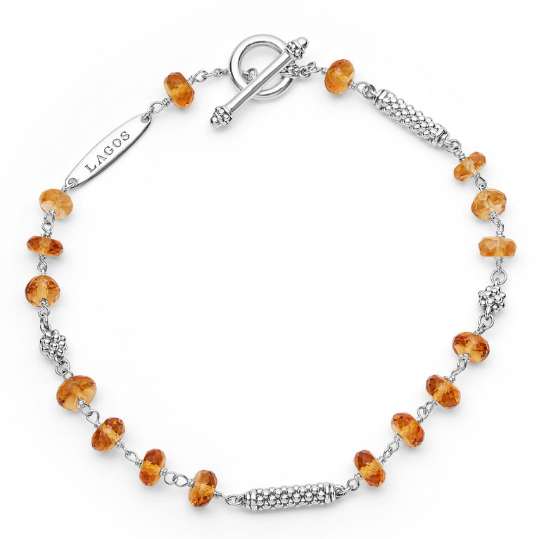 A sterling silver bracelet is displayed in the middle of a white background featuring citrine ceramic and sterling silver Caviar beads.