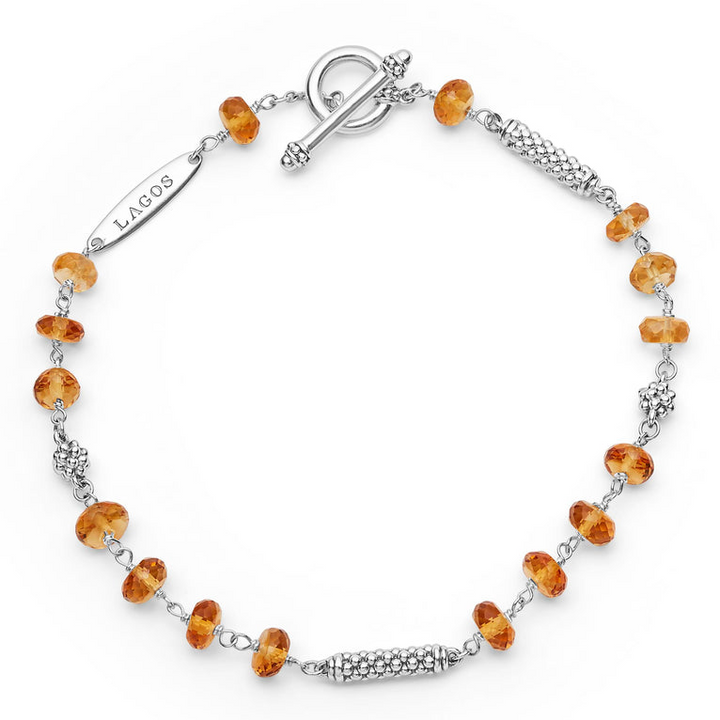 A sterling silver bracelet is displayed in the middle of a white background featuring citrine ceramic and sterling silver Caviar beads.