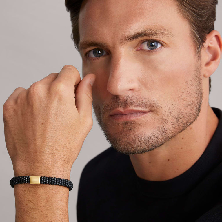 A man is wearing sterling silver beaded bracelet, featuring Matte black ceramic caviar beading and a gold single station